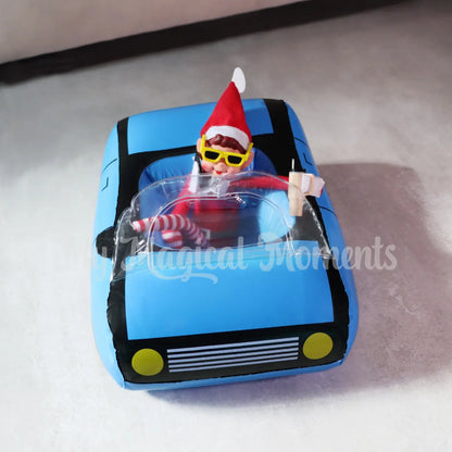 ELves behavin badly talking on a mini elf phone drinking a stanley cup in a mini car with sunglasses