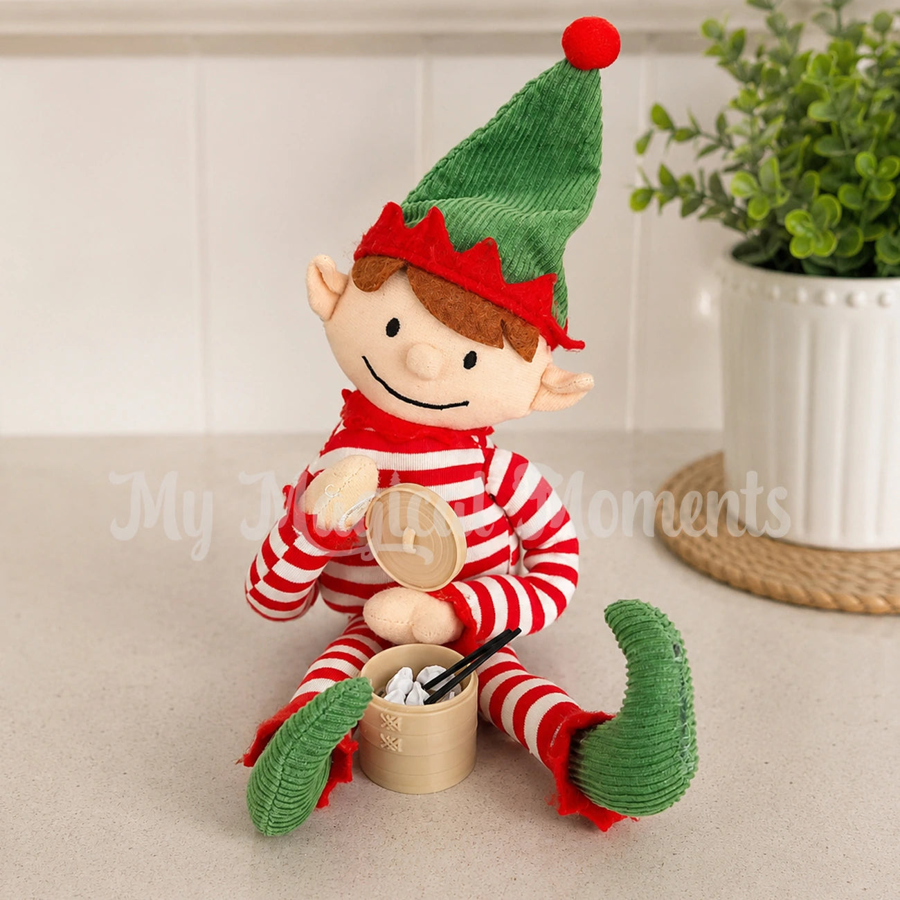 elf for Christmas holding a little dumpling steaming basket with mini dumplings and chopsticks