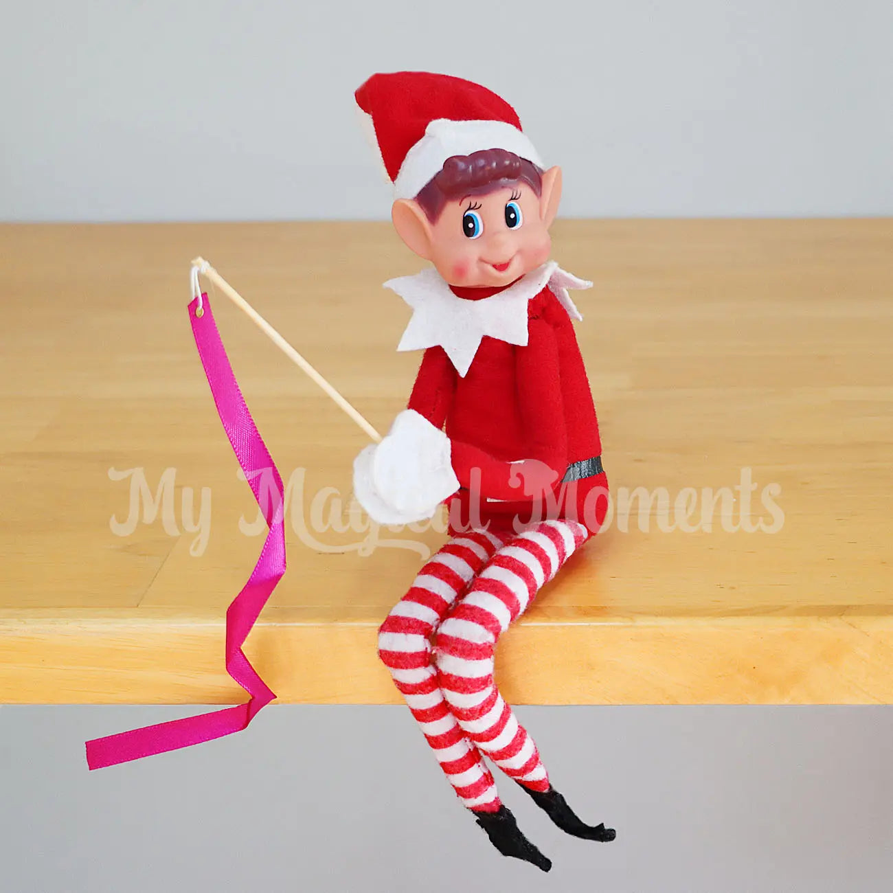 Elf holding a miniature ribbon