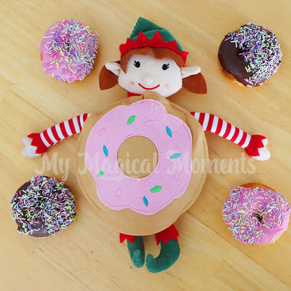 Elf for Christmas wearing a donut costume surrounded by donuts