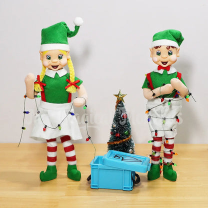 My Elf Friends Standing and holding mini Christmas Lights, Brown Hair boy is tangled in the lights coming out of an elf sized container and a Christmas tree