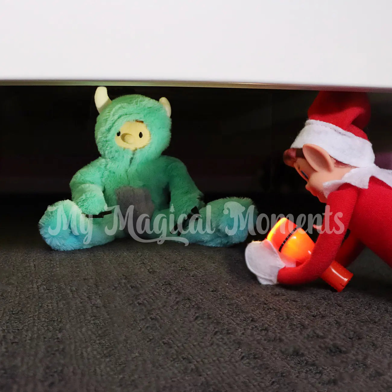 Elf For Christmas wearing a Monsters Costume hiding under the bed with an elf with a flashlight