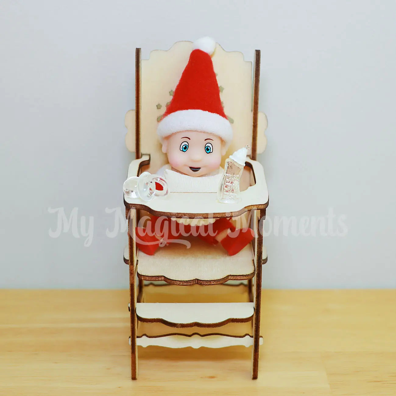 Elf baby in a high chair with mini bottle and dummy