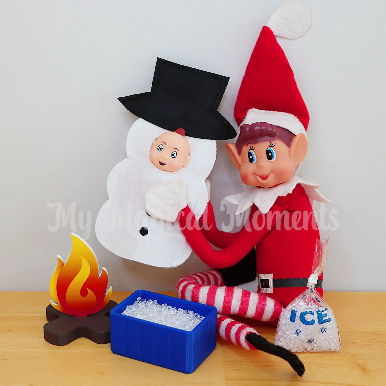 Elf making ice by melting a baby snowman over a miniature fire pit