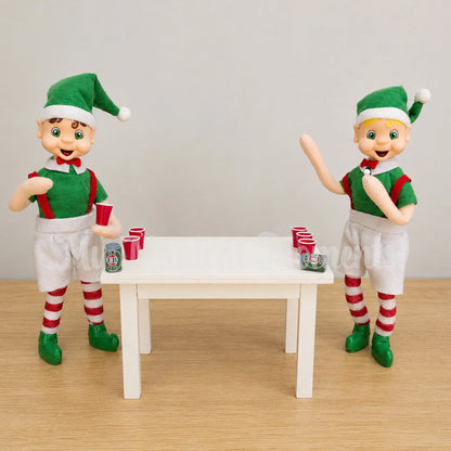 Brown hair bendable standing elf playing beer pong with a blonde hair bendable elf. They have mini beers on a wooden table and red cups