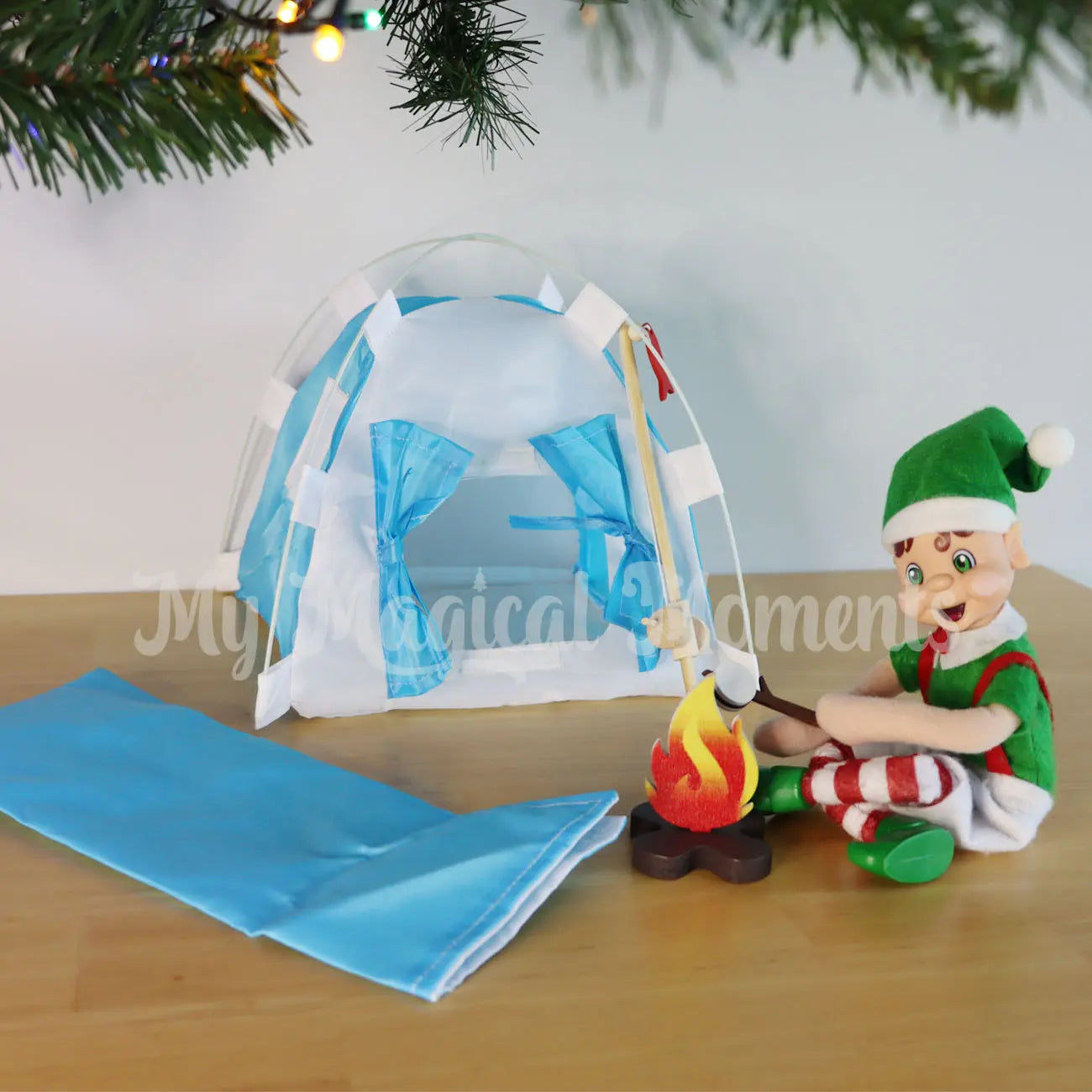 Elf sitting under the Christmas tree toasting Marshmallows with their mini camping set