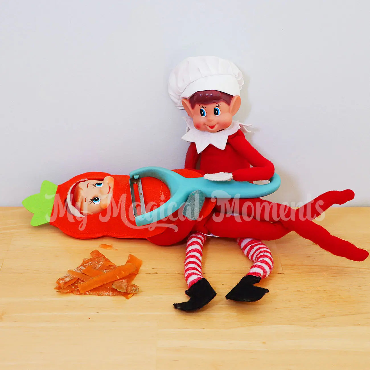 Elf wearing a carrot costume being peeled by an elf