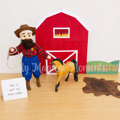 Elf wearing a cowboy hat, cowboy boots, a sherrif badge, blue pants, flannel shirt and beard. With a horse in front of Printable barn, grass and mud splat. There is a sign that says this ain't my first rodeo
