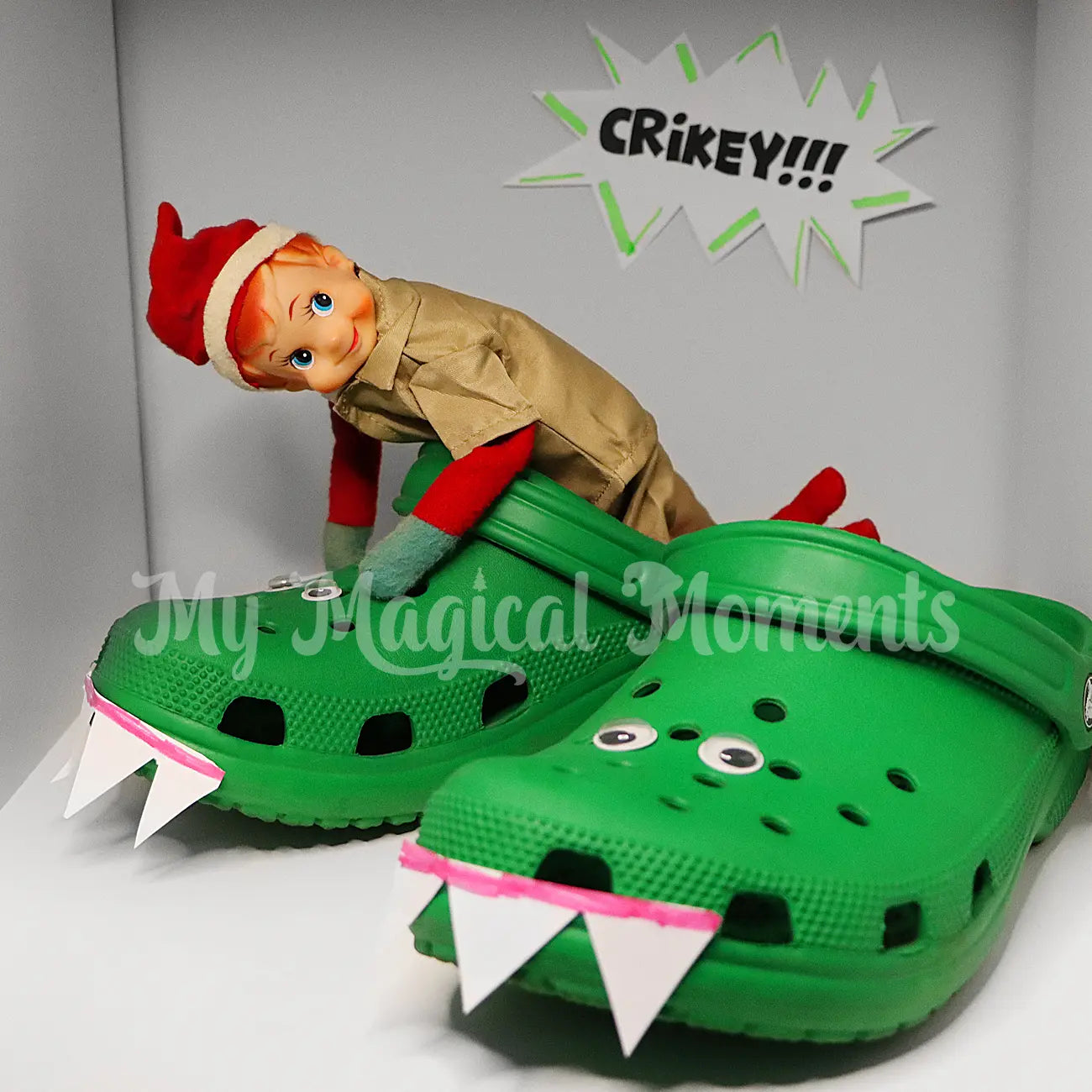 elf wearing a zoo keeper/ croc hunter uniform wrestling with a pair of croc shoes