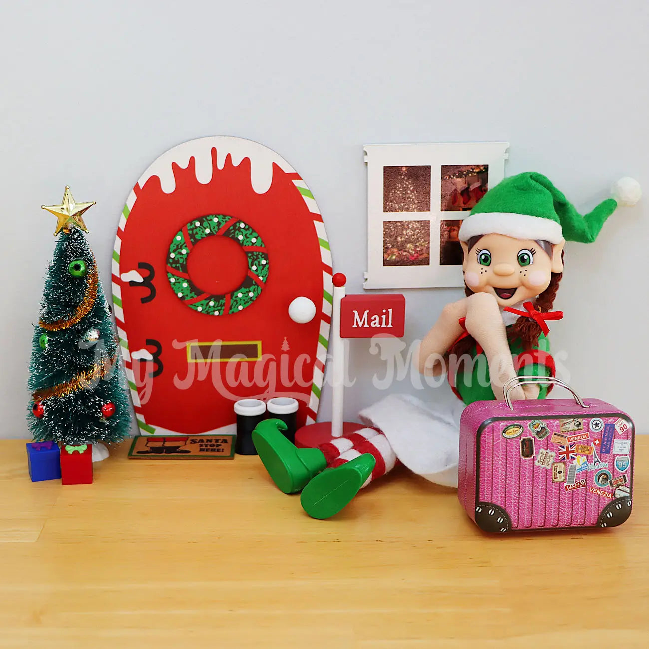 Brown hair Elf Arriving with a suitcase by an elf door, mini door mat, tree and presents