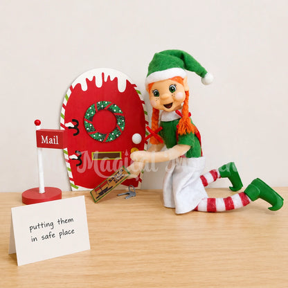 Elf putting her house keys under the door mat of a elf door and mailbox. there is a sign that reads putting them in a safe place