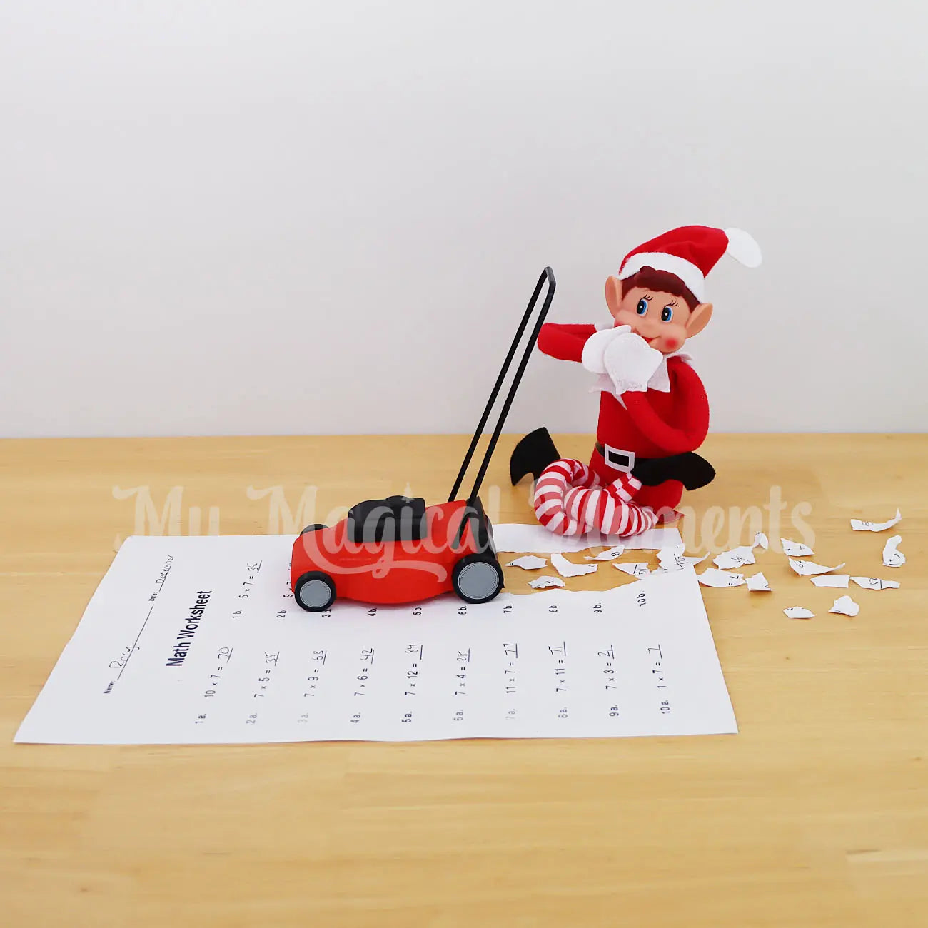 Elf Mowing over kids homework with a elf sized lawn mower prop