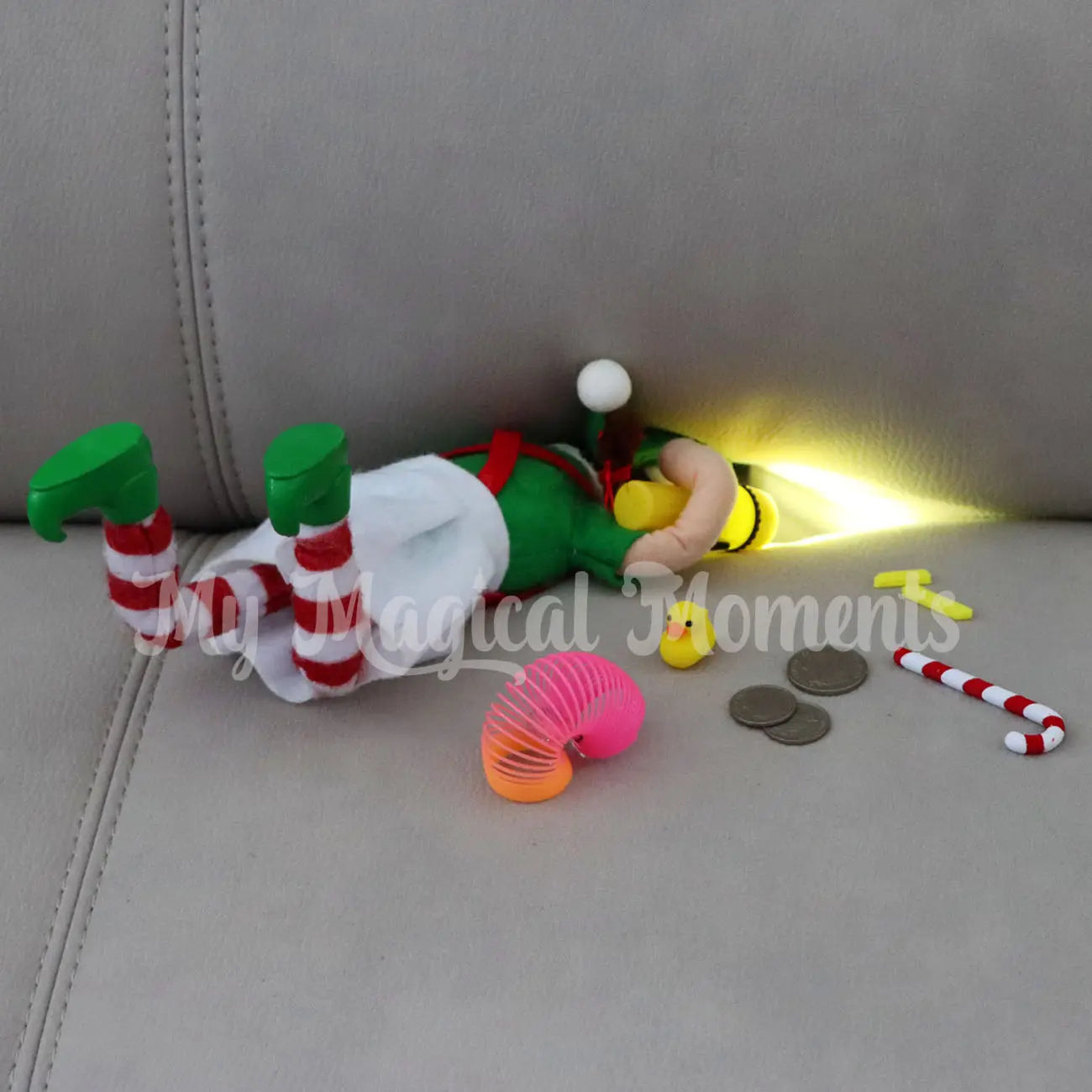 Bendable Elf Looking for loose change in the couch with a torch. Finding chips, candy cane, change, rubber duck and a slinky