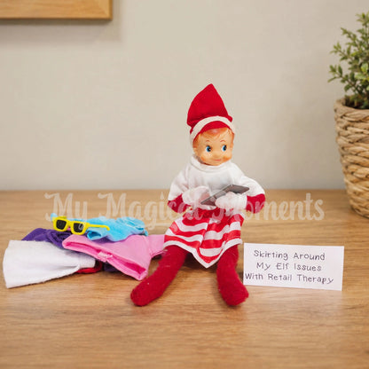 elf wearing a skirt, with a pile of coloured shirts on a tablet saying, skirting around my elf issues with retail therapy