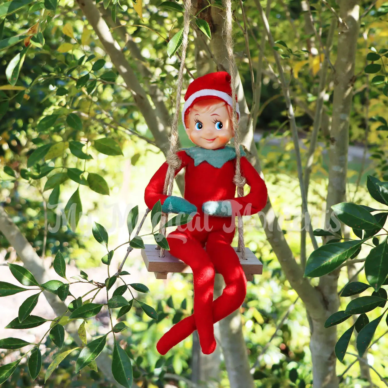 Elf on a miniature wooden swing in a tree