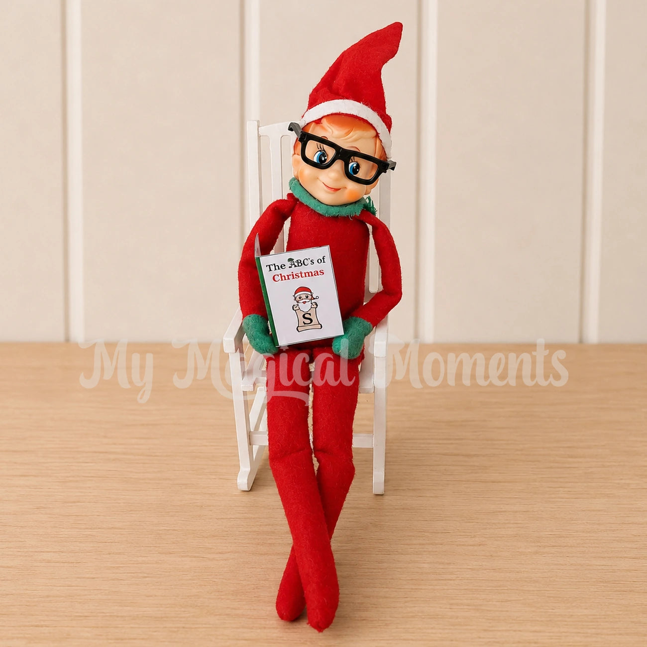 an elf wearing reading glasses reading a mini book