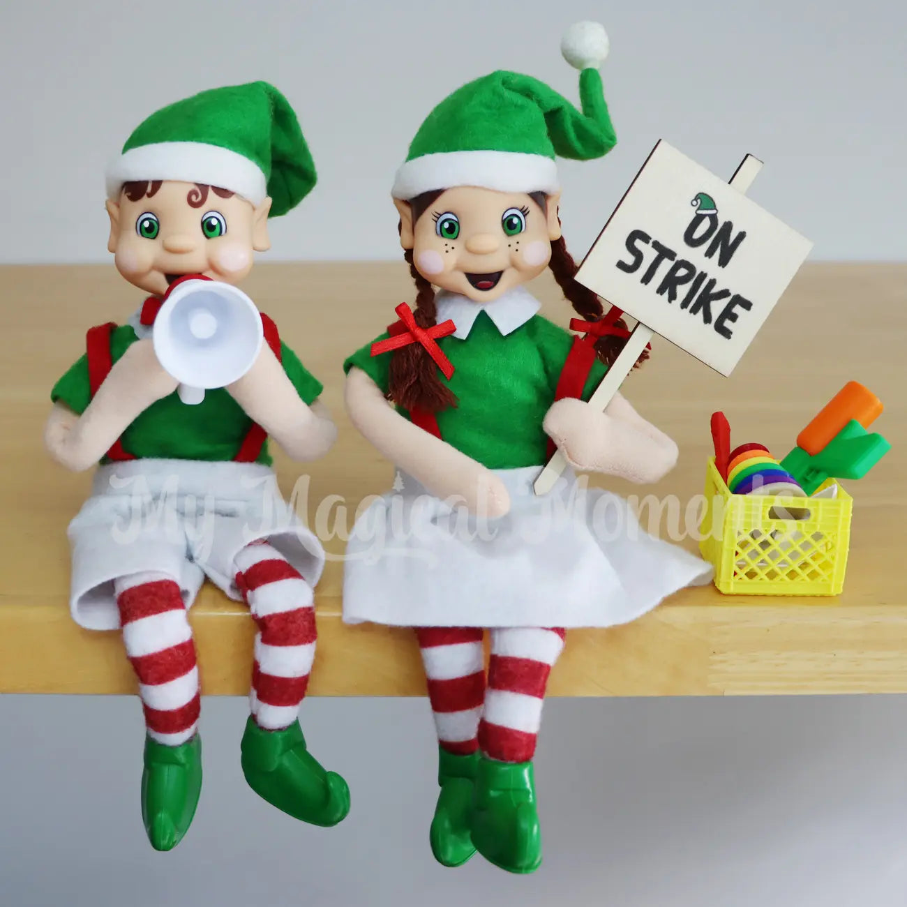 Elves on strike holding a strike sign, miniature megaphone and crate full of toys