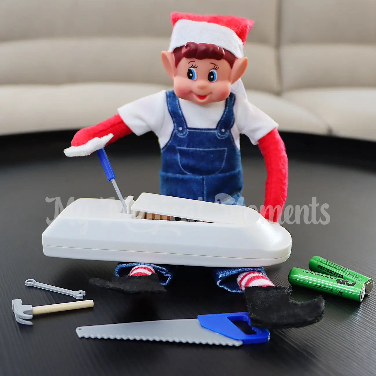 elf wearing overalls fixing in the remote with miniature elf tools