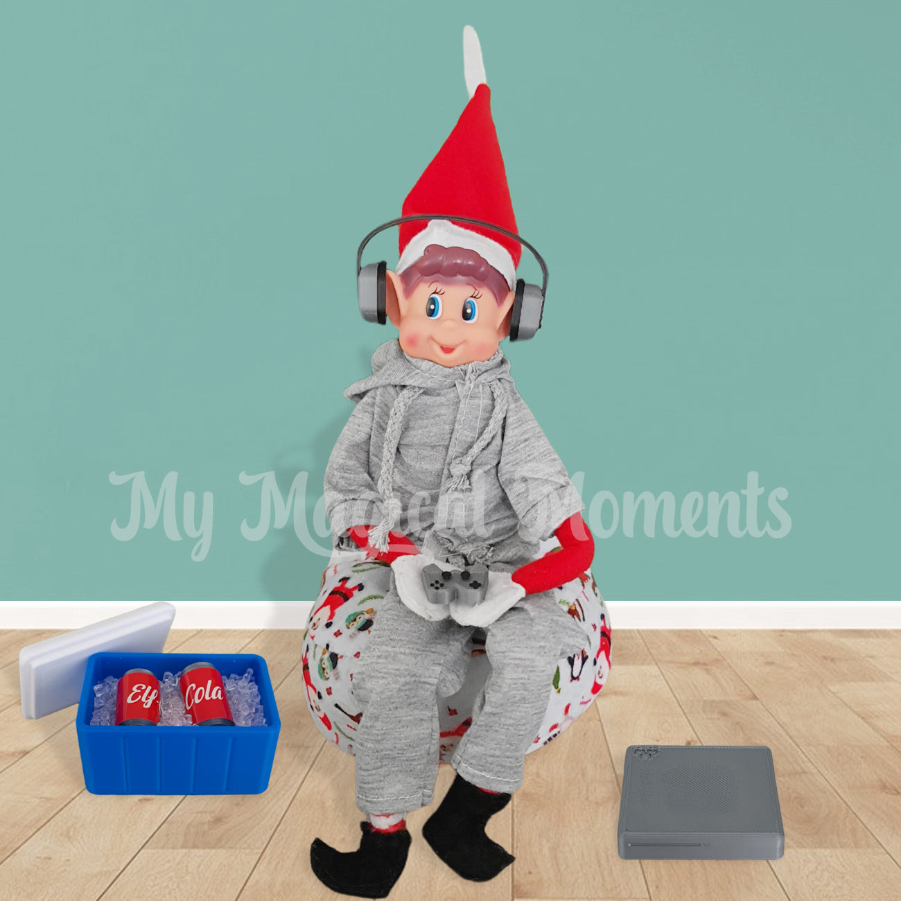 Elves behavin badly gaming in tracksuit with headphones. Esky full of cola is next to his bean bag