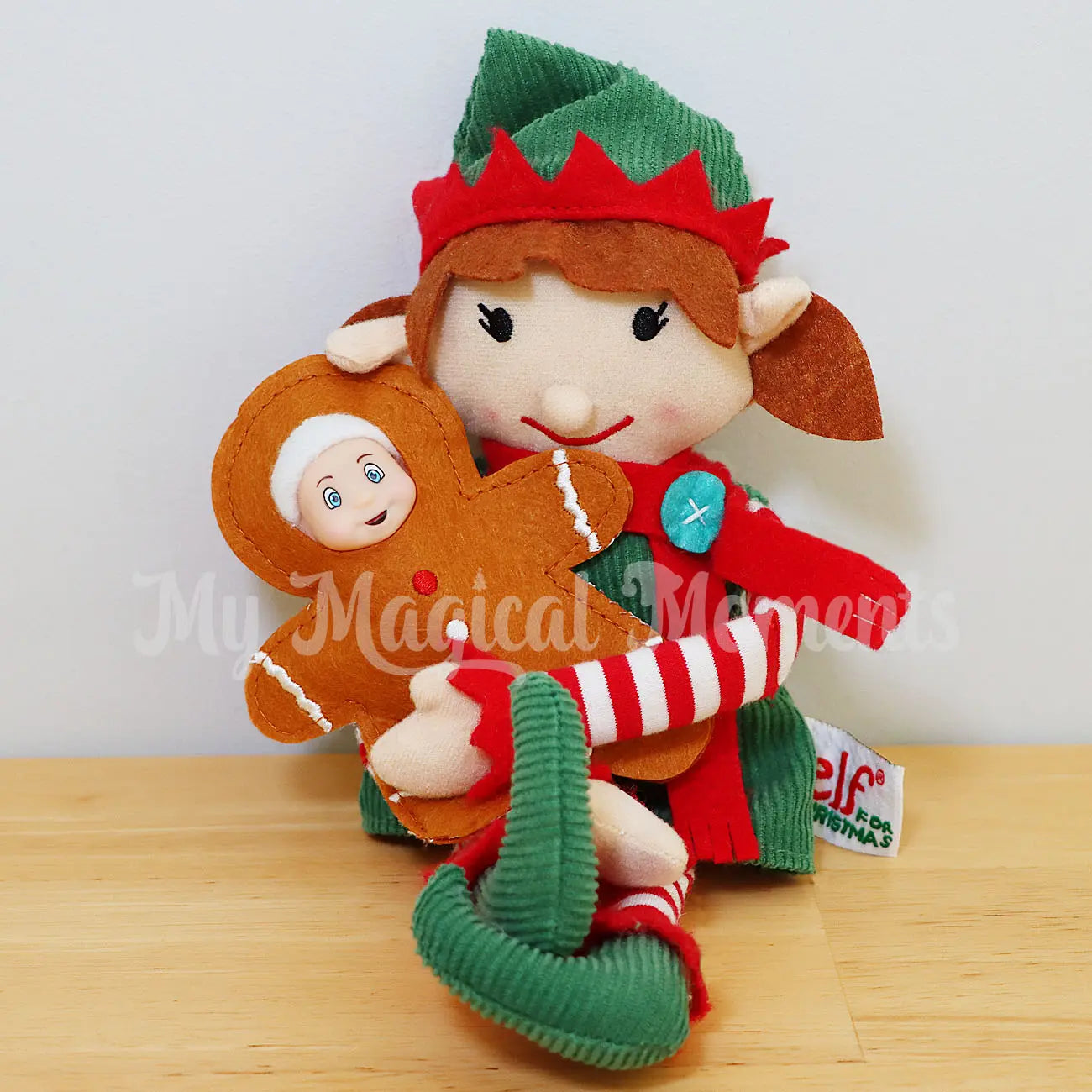 Elf baby wearing a gingerbread costume held by an elf adult