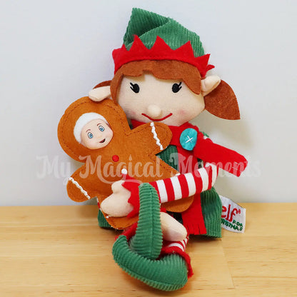 Elf baby wearing a gingerbread costume held by an elf adult