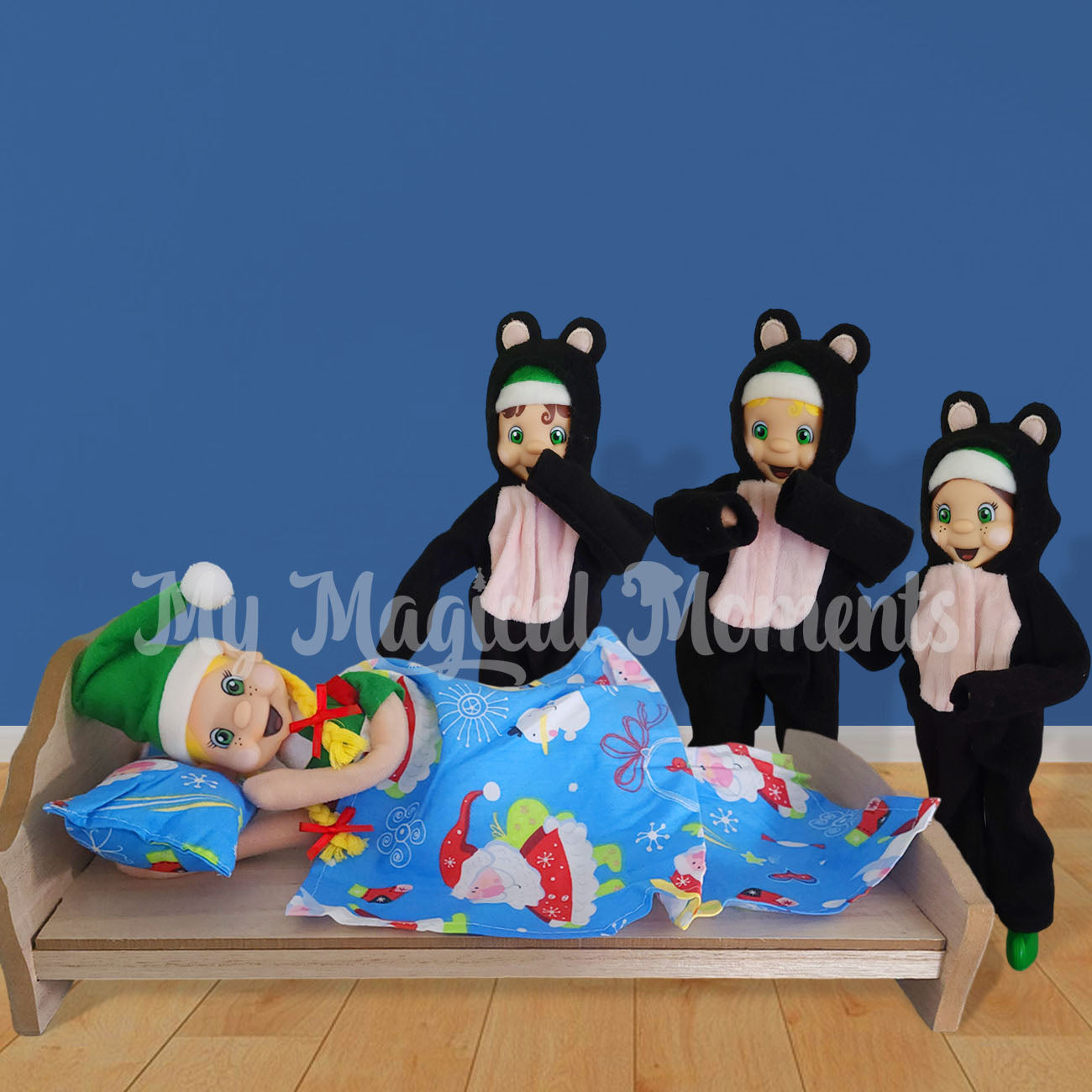 elf laying in mini bed, sleeping from 3 elves dressed as bears