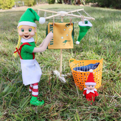 Elf hanging washing in the backyard on a miniature clothesline with peg basket