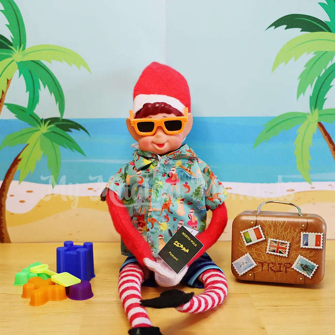 Elves behavin badly elf wearing mini sunnies and an hawaiian shirt with beach toys and a suitcase