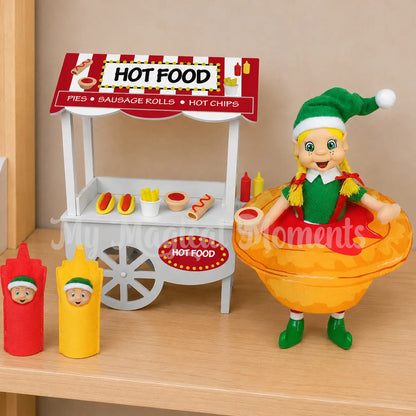 Hot food stand with mini elf food with an elf wearing a pie costume