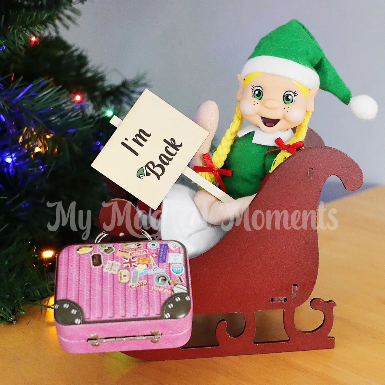 Elf arriving back in  a sleigh, suitcase and i'm back sign