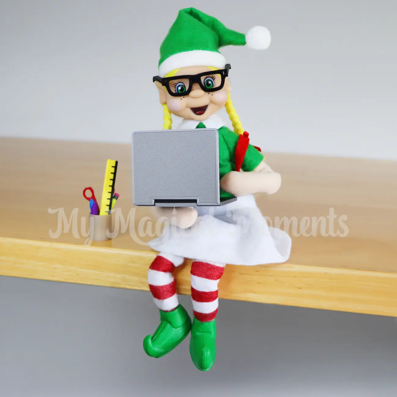 Elf using a elf sized laptop prop and stationery props