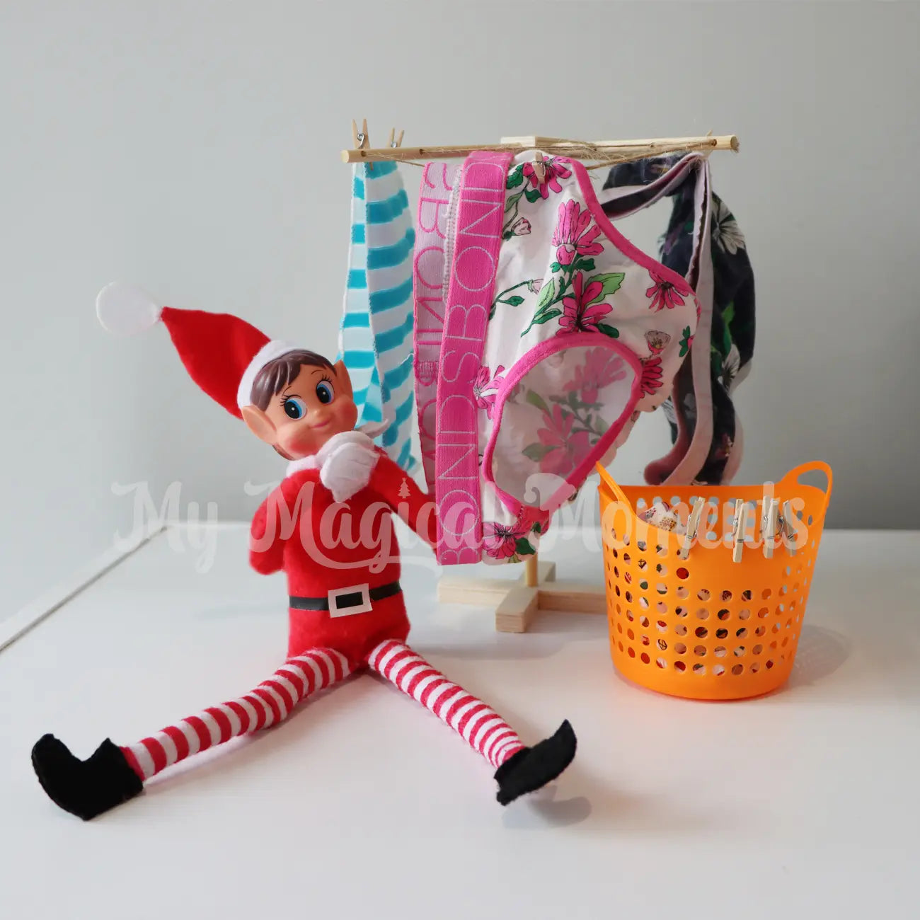 Elf hanging washing with miniature clothesline and laundry basket