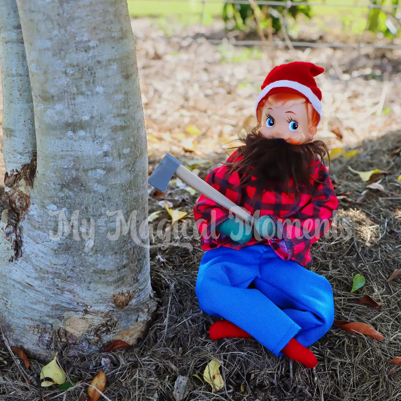 Elf dressed as a lumberjack chopping down a tree