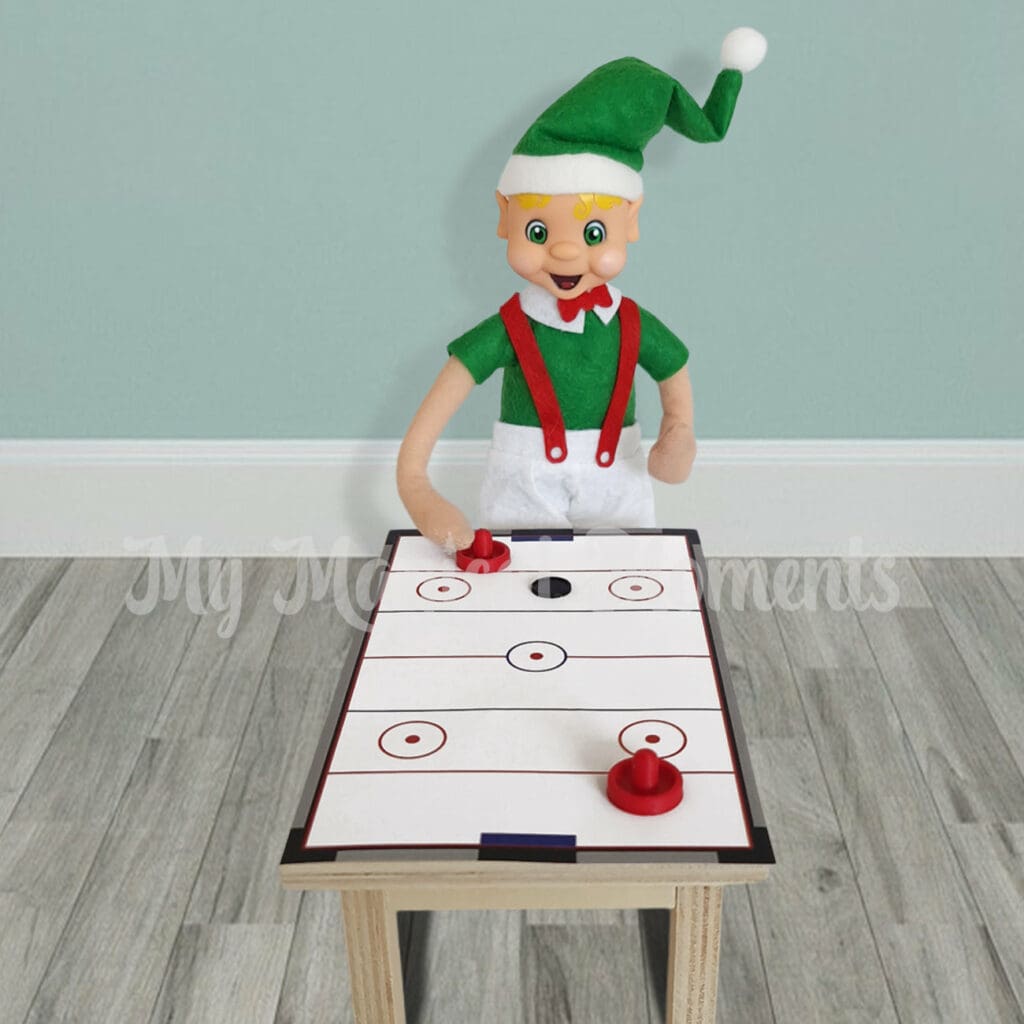 elf playing air hockey on a table