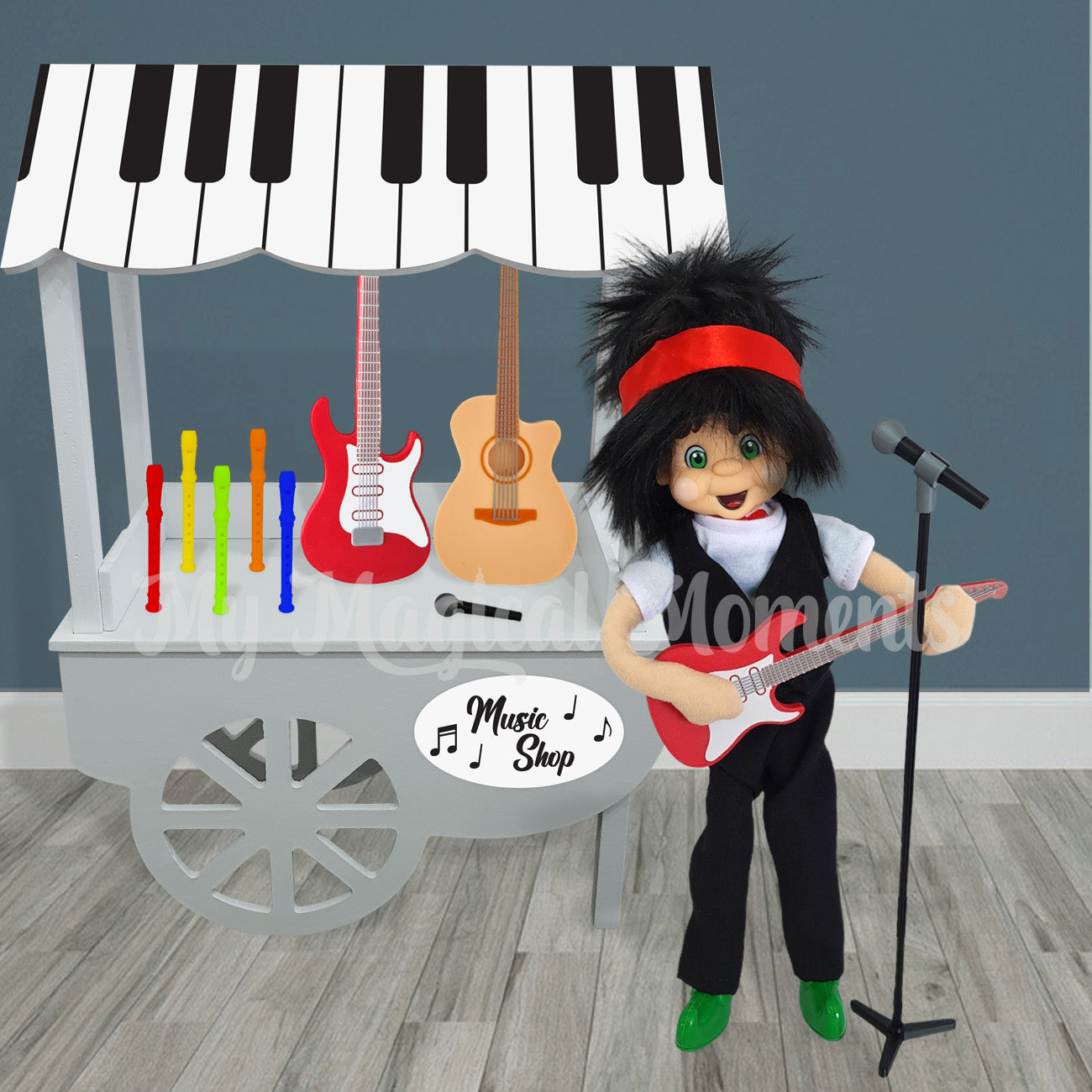 Elf dressed as a rockstar selling instruments from his miniature music shop. He is playing a miniature electric guitar