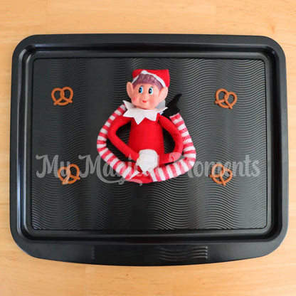 elf in a pretzel with mini pretzels on a baking tray