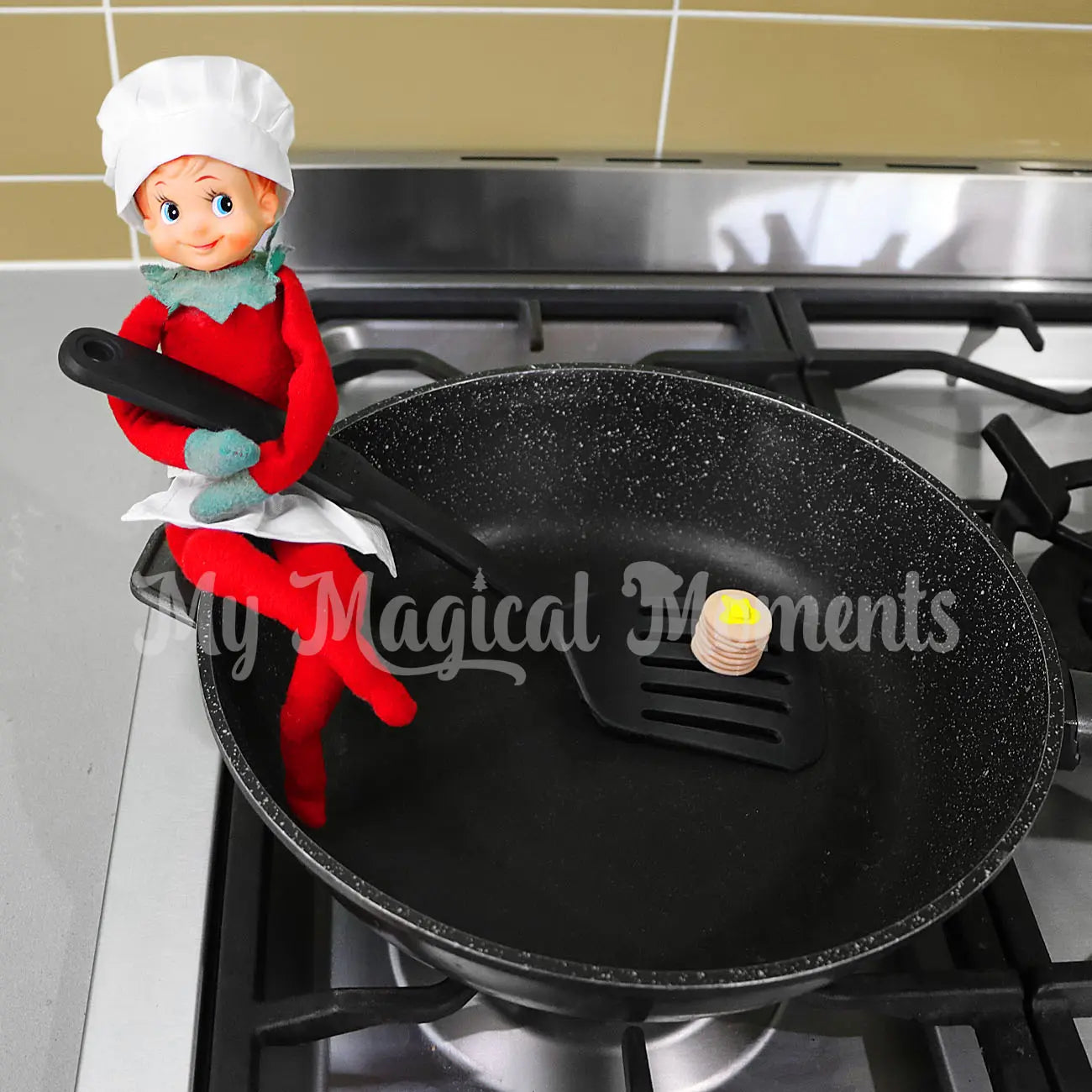 Elf wearing a chef outfit making mini pancakes in the pan