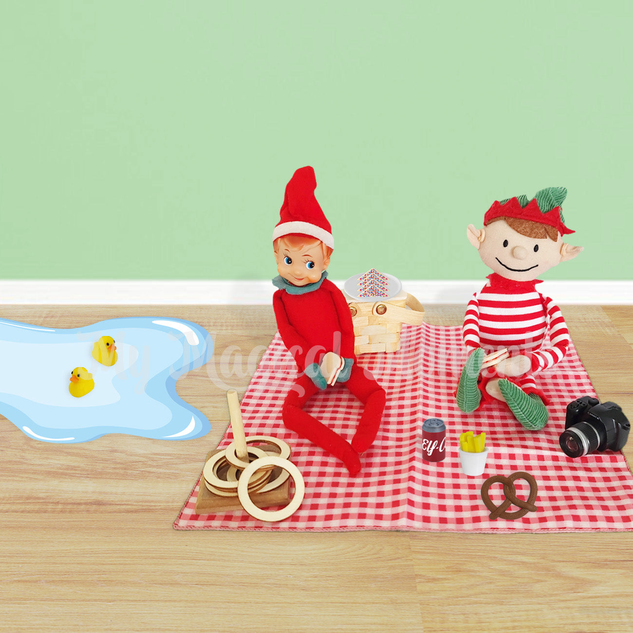 Picnic scene with elf for Christmas wearing hearing aids. There is a miniature picnic basket and ring toss with a puddle of water with ducks