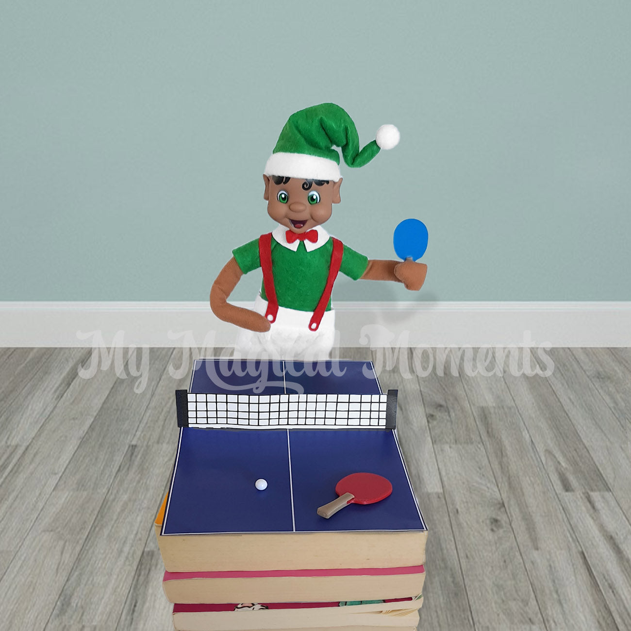 Elf playing Ping pong with miniature paddles and a ping pong ball on books