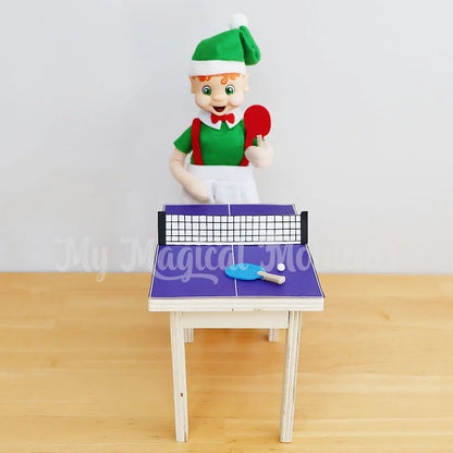 elf playing with a miniature ping pong table