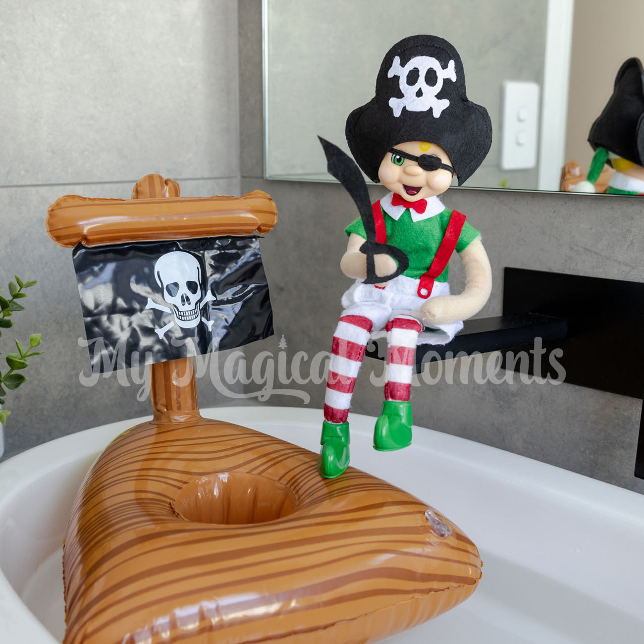 elf dressed as a pirate sitting in the bathroom with mini pirate ship