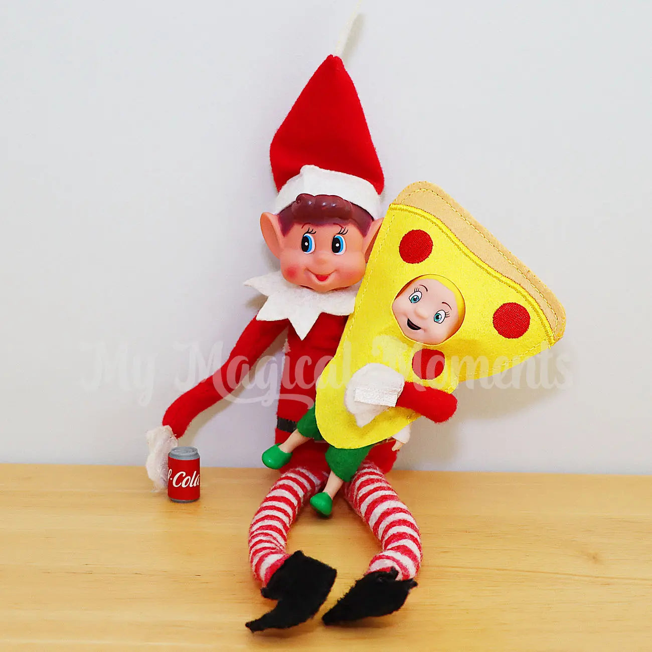 Elf toddler wearing a Pizza costume, being held by an elf with a cola