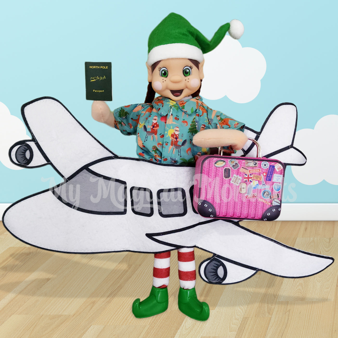 My Elf friends standing holding a printable passport in a aeroplane costume with their pink suitcase prop
