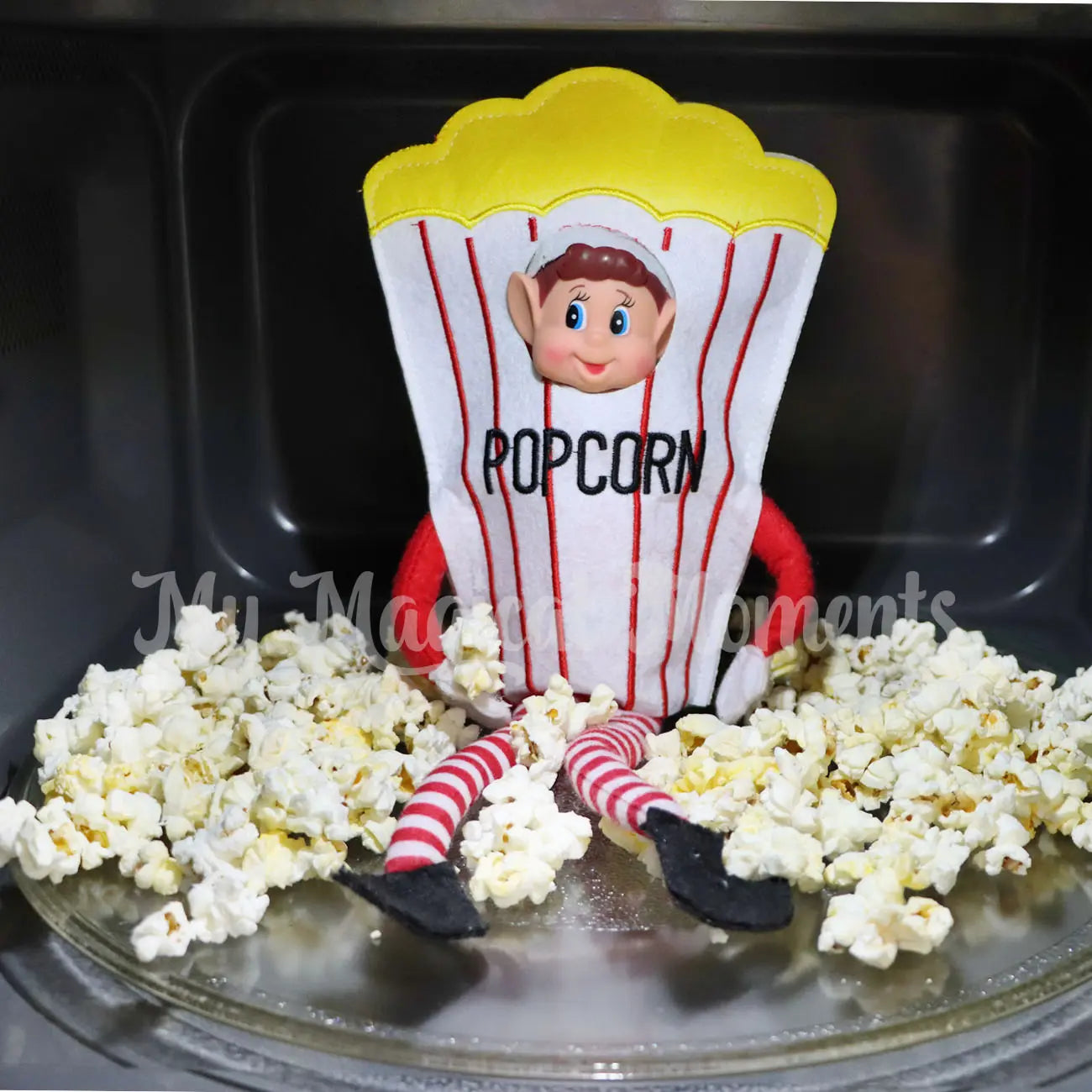 Elf wearing a popcorn outfit in a microwave surrounded by popcorn