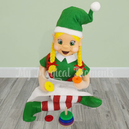 Blonde hair elf playing with a miniature Ring Stacker prop