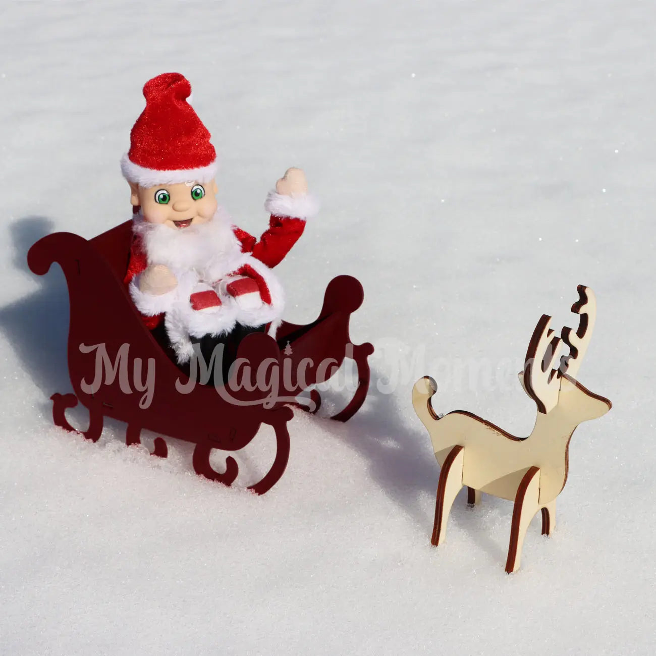 elf dressed as Santa in a  red sleigh and reindeer