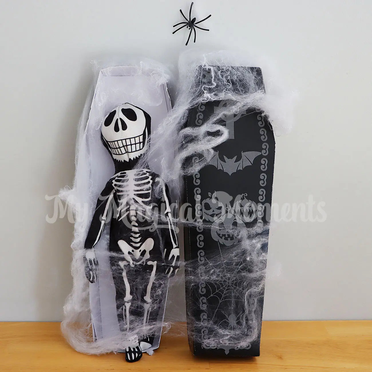 Elf wearing a skeleton costume in a printable coffin with spider webs