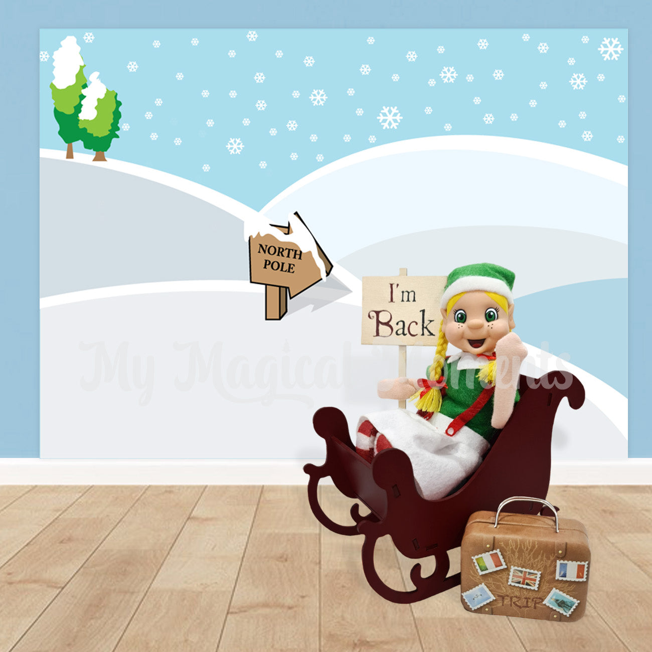 elf sitting in a sleigh with an I'm back sign and suitcase