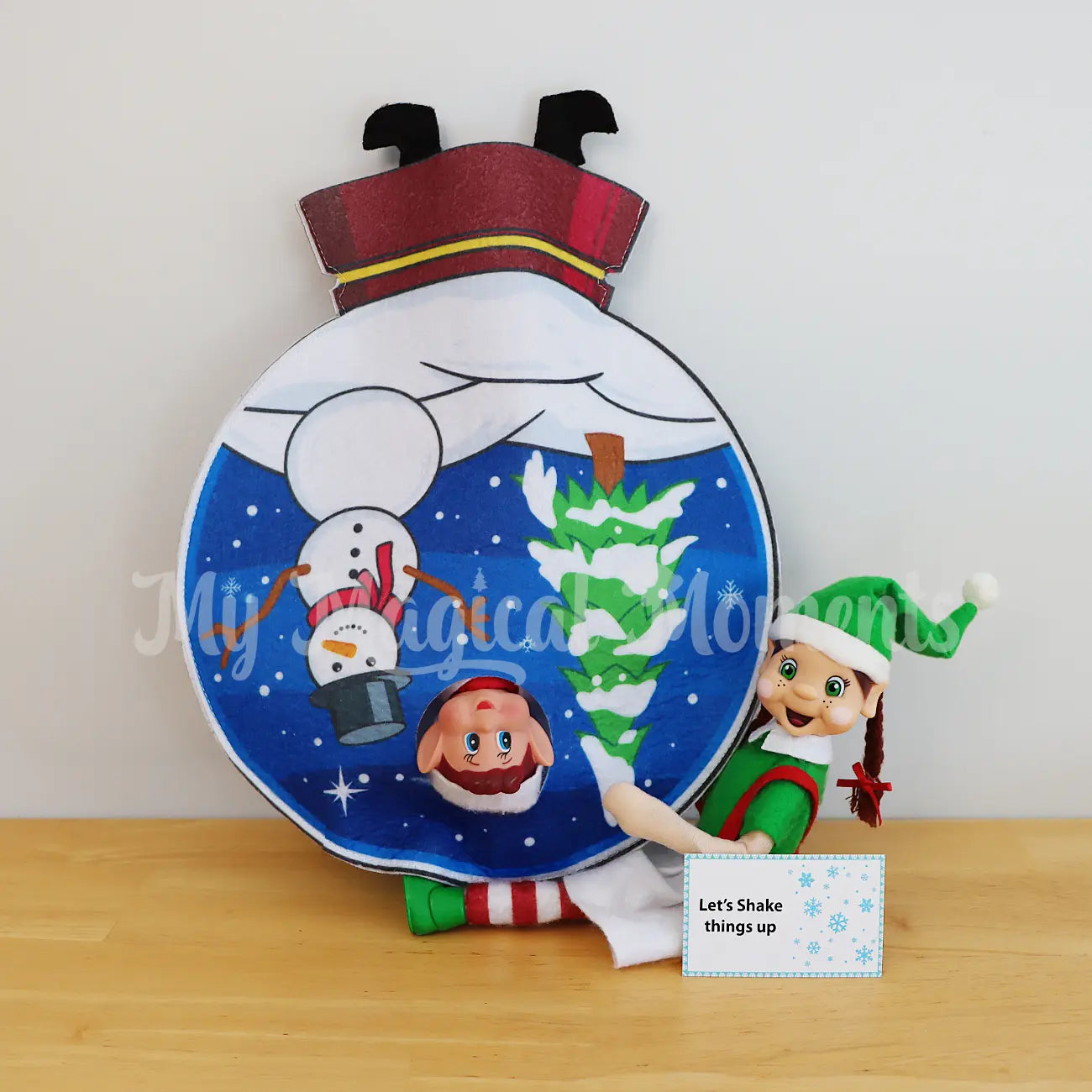 Shake it up, with an elf holding a snow globe worn by an elf