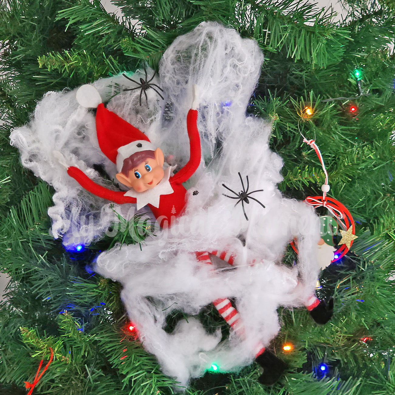 Elves behavin badly stuck in spider web on the Christmas tree. Miniature fly props are also caught in the web